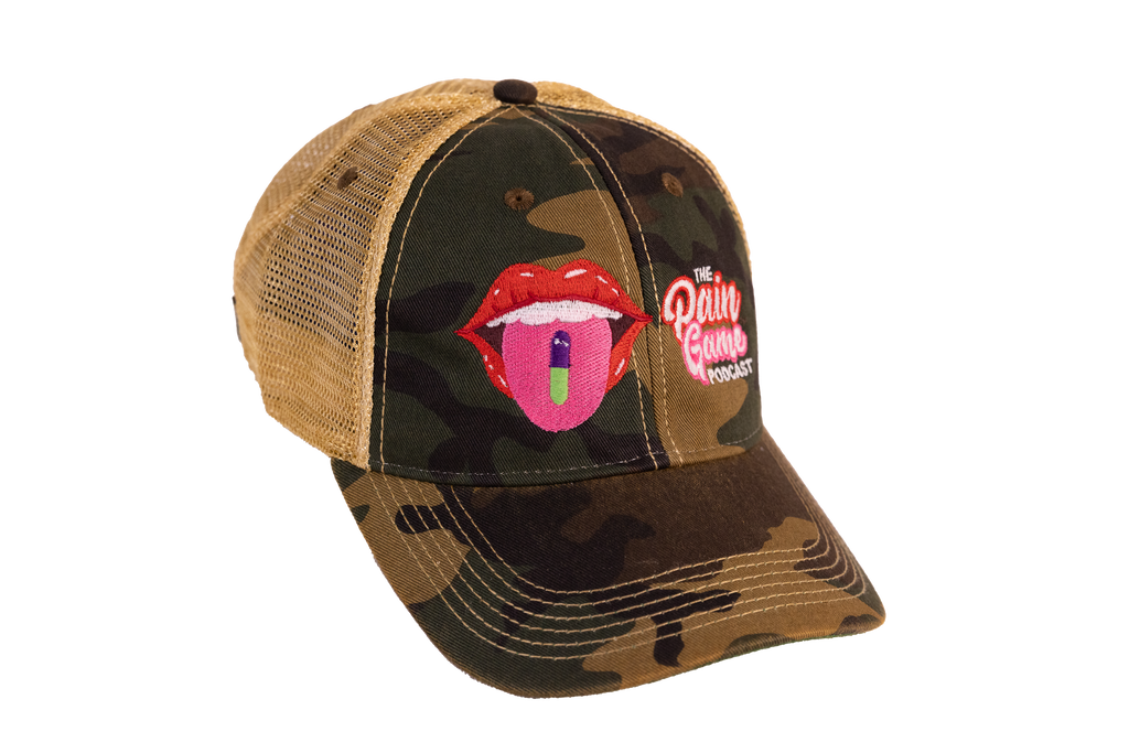 Camouflage cap with a graphic of red lips and a pink object, featuring 'The Pain Game Podcast' logo.